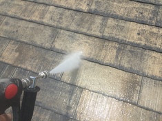 屋根塗装　高圧洗浄中 高圧洗浄で屋根に付着しているコケと汚れを落としていきます。