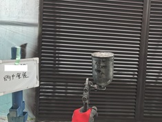 雨戸 吹付施工中 はけ目やローラーの目がでないように吹き付けで仕上げます。
